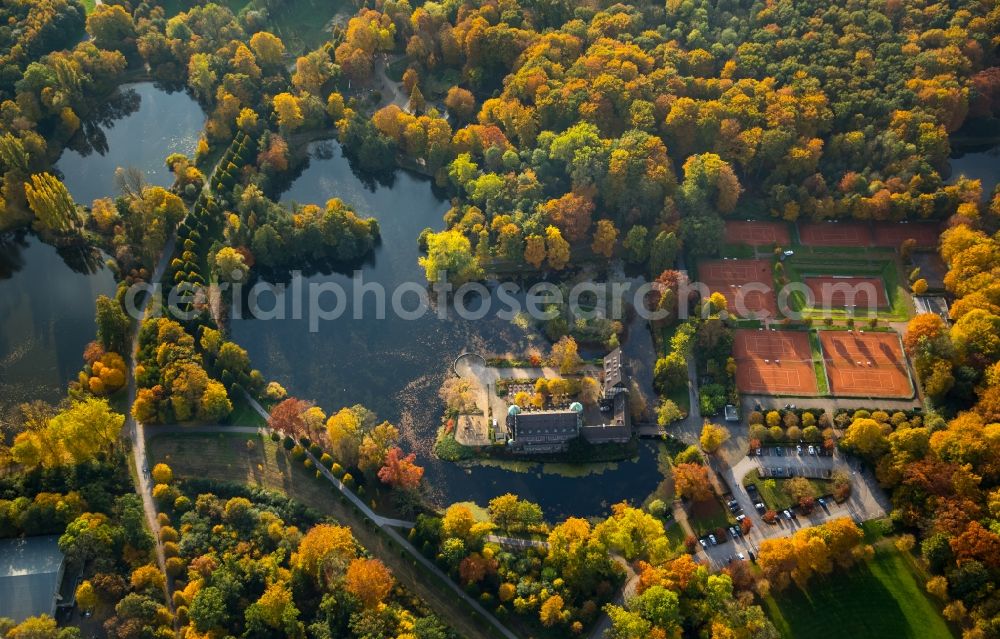 Gladbeck from the bird's eye view: Autumnal surrounding landscape of the water castle Wittringen in the South of Gladbeck in the state of North Rhine-Westphalia. The castle is located adjacent to ponds and waters near tennis courts