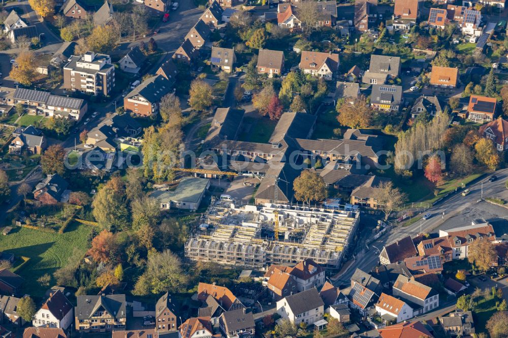 Aerial photograph Warendorf - Autumnal discolored vegetation view construction site of the new buildings of the retirement home - retirement Altenheim Dechaneihof St. Marien on street Warendorfer Strasse in the district Freckenhorst in Warendorf in the state North Rhine-Westphalia, Germany