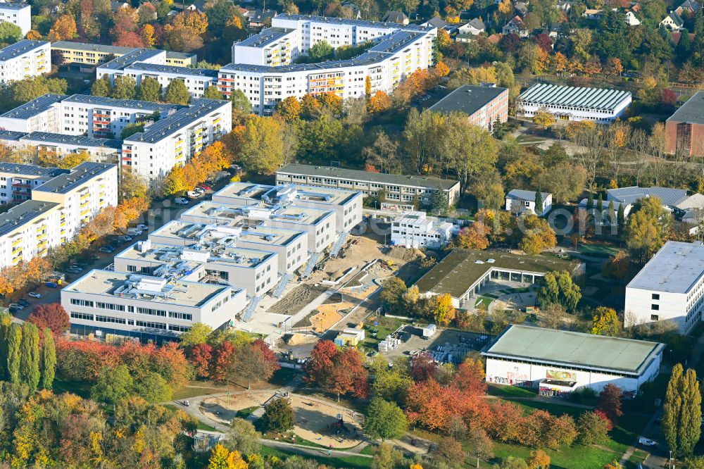 Berlin from above - Autumnal discolored vegetation view new construction site of the school building Gymnasium with Sporthalle on street Erich-Kaestner-Strasse - Peter-Huchel-Strasse in the district Hellersdorf in Berlin, Germany