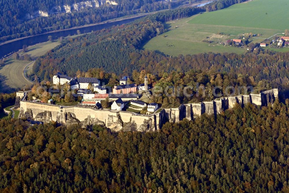 Aerial photograph Königstein - Autumnal discolored vegetation view the Fortress Koenigstein at the river Elbe in the county district of Saxon Switzerland East Erzgebirge in the state of Saxony. The fortress is one of the largest mountain fortresses in Europe and is located amidst the Elbe sand stone mountains on the flat top mountain of the same name