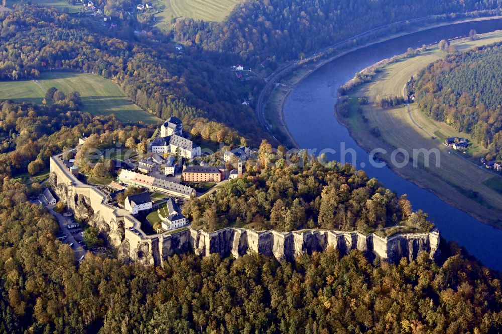 Aerial image Königstein - Autumnal discolored vegetation view the Fortress Koenigstein at the river Elbe in the county district of Saxon Switzerland East Erzgebirge in the state of Saxony. The fortress is one of the largest mountain fortresses in Europe and is located amidst the Elbe sand stone mountains on the flat top mountain of the same name