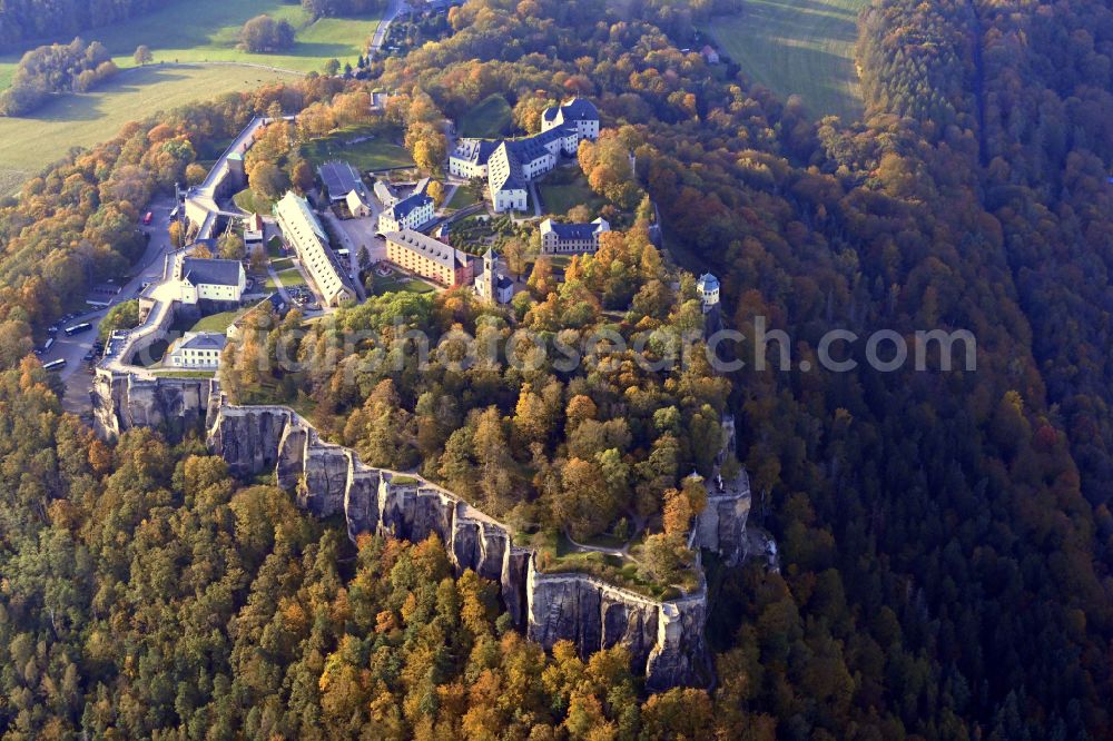 Aerial photograph Königstein - Autumnal discolored vegetation view the Fortress Koenigstein at the river Elbe in the county district of Saxon Switzerland East Erzgebirge in the state of Saxony. The fortress is one of the largest mountain fortresses in Europe and is located amidst the Elbe sand stone mountains on the flat top mountain of the same name