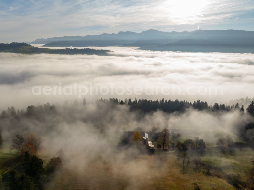 Irsengund from the bird's eye view: Autumnal colored vegetation view. Weather-related fog banks and cloud layer over forest and meadow landscape in the Allgaeu in the district of Oberreute in Irsengund in the federal state of Bavaria, Germany