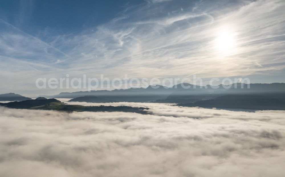 Irsengund from above - Autumnal colored vegetation view. Weather-related fog banks and cloud layer over forest and meadow landscape in the Allgaeu in the district of Oberreute in Irsengund in the federal state of Bavaria, Germany