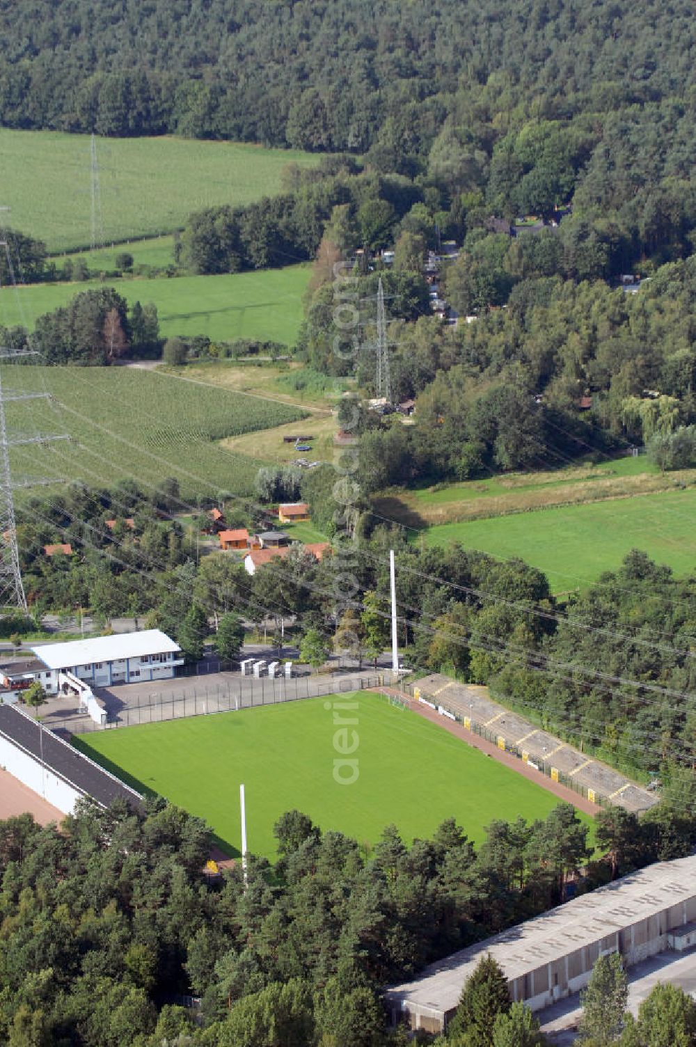 Paderborn from the bird's eye view: Blick auf das Hermann-Löns-Stadion. Die Wettkampfstätte im Paderborner Stadtteil Schloß Neuhaus war bis Ende der Saison 2007/08 Heimstadion des deutschen Fußball-Zweitligisten SC Paderborn 07. Seit Sommer 2008 ist das Stadion Heimstätte des American Footballclub A.F.C. Paderborn Dolphins e.V. Das Hermann-Löns-Stadion umfasst drei Tribünen mit einer Kapazität von ca. 10.000 Plätzen. Davon sind 3.604 überdachte Sitzplätze, der Rest sind Stehplätze. Der Gästebereich bietet ca. 3.000 Zuschauern auf 2.414 Steh- und 369 Sitzplätzen Platz. Direkt über das Stadion führt ein Hochapannungsleitung. Adresse: Hermann-Löns-Straße 127, 33104 Paderborn; Kontakt: AFC Paderborn Dolphins e.V., Kirschenkamp 8, 33106 Paderborn, Tel. +49(0)5254 9308-71, Fax +49(0)5254 9308-64, info@paderborn-dolphins.de