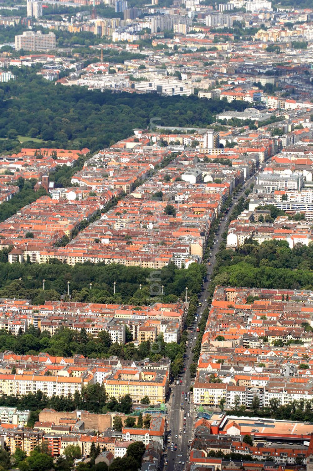 Berlin from above - Blick auf die Hermannstraße im Berliner Bezirk Neukölln. Sie führt direkt durch das Wohngebiet mit seinen Mehrfamilienhäusern, wobei sie sich im unteren Teil des Bildes als Hermannbrücke über den S-Bahnhof Hermannstraße mit seinem Einkaufszentrum, dem Hermann Quartier, zieht. Neben den vielen Wohn- und Geschäftshäusern findet man auch mehrere Kirchhöfe, in denen sich insgesamt 8 Friedhöfe befinden. Im Bildhintergrund bekommt man einen Ausblick auf den Bezirk Friedrichshain-Kreuzberg. Kontakt: