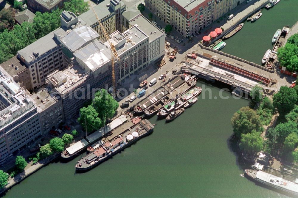 Berlin from above - A collection of historical tugboats and barges at the Historischer Hafen harbor in central Berlin lies at anchor. You can see the Inselbrücke to Fischerinsel during extensive construction work