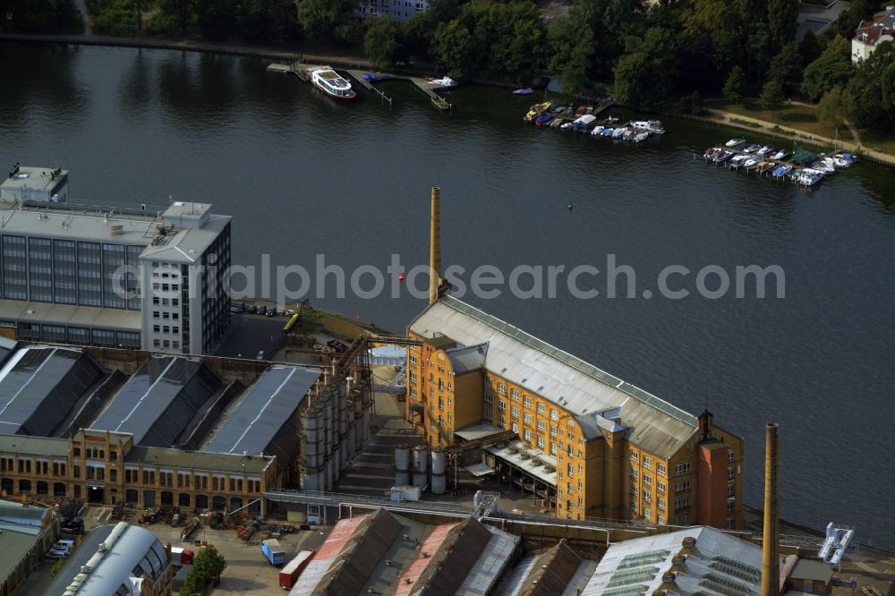 Aerial image Berlin - Historic factory building on the industrial area on Wilhelminenhofstrasse on the riverbank of the Spree in the Oberschoeneweide part of Berlin in Germany. The building with its chimney and yellow facade is located on the river