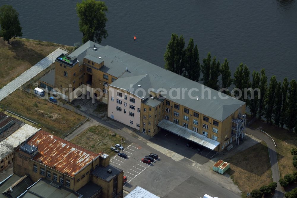 Aerial image Berlin - Historic factory building at Platz am Kaisersteg on the riverbank of the Spree in the Oberschoeneweide part of Berlin in Germany. The building is located in the industrial area amidst factories and industrial sites on the riverbank