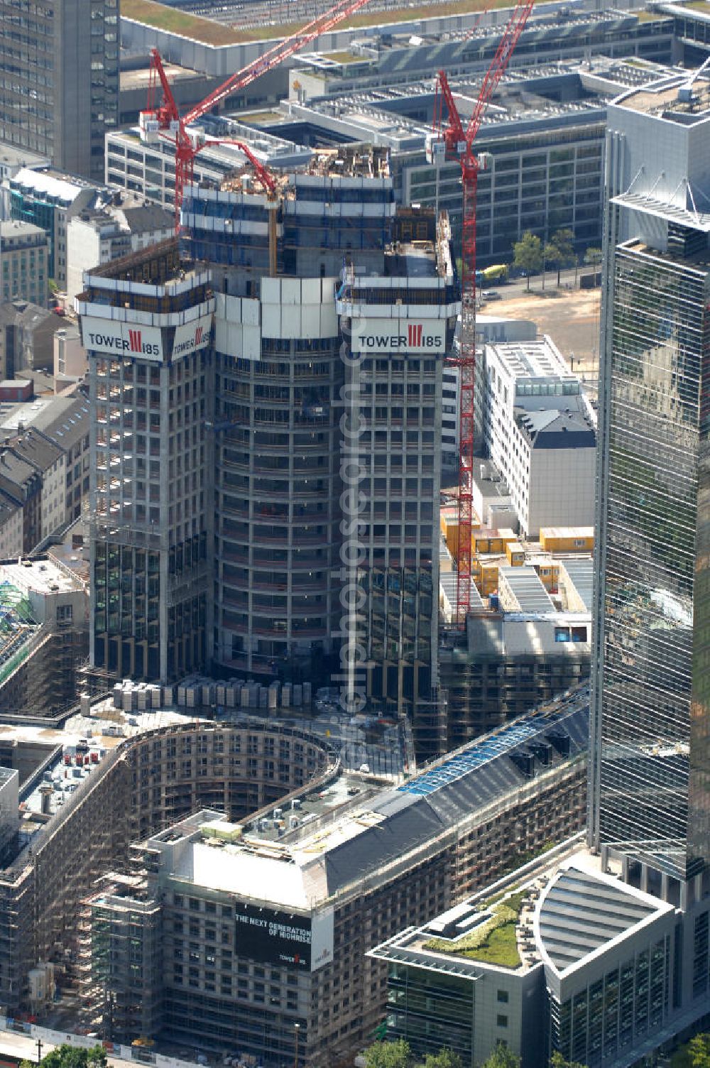 Frankfurt am Main from the bird's eye view: Blick auf die Baustelle des Tower 185 , dem derzeit höchstem, in Deutschland im Bau befindlichen Wolkenkratzer. Bauherr ist die Vivico Real Estate. Die Wirtschaftsprüfungsgesellschaft PricewaterhouseCoopers (PwC) hat bereits vor Baubeginn 60.000 Quadratmeter von insgesamt rund 90.000 Quadratmeter Bürofläche langfristig angemietet und wird hier ihre neue Deutschland-Zentrale beziehen. Den Entwurf für den Tower 185 lieferte der Frankfurter Architekt Christoph Mäckler. Er sieht ein hufeisenförmig angelegtes Sockelgebäude vor, aus dem sich die beiden Hochhaushälften mit einer Aluminium-Glas-Fassade erheben. View of the construction site of Tower 185, currently the highest in Germany under construction skyscraper. Owner is the Vivico real estate.