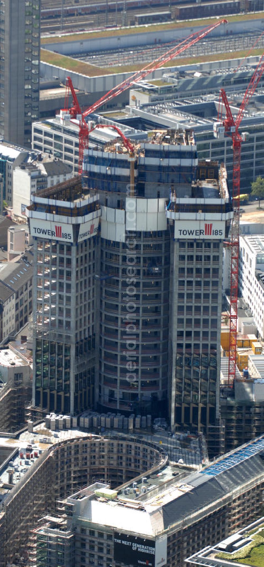 Frankfurt am Main from above - Blick auf die Baustelle des Tower 185 , dem derzeit höchstem, in Deutschland im Bau befindlichen Wolkenkratzer. Bauherr ist die Vivico Real Estate. Die Wirtschaftsprüfungsgesellschaft PricewaterhouseCoopers (PwC) hat bereits vor Baubeginn 60.000 Quadratmeter von insgesamt rund 90.000 Quadratmeter Bürofläche langfristig angemietet und wird hier ihre neue Deutschland-Zentrale beziehen. Den Entwurf für den Tower 185 lieferte der Frankfurter Architekt Christoph Mäckler. Er sieht ein hufeisenförmig angelegtes Sockelgebäude vor, aus dem sich die beiden Hochhaushälften mit einer Aluminium-Glas-Fassade erheben. View of the construction site of Tower 185, currently the highest in Germany under construction skyscraper. Owner is the Vivico real estate.