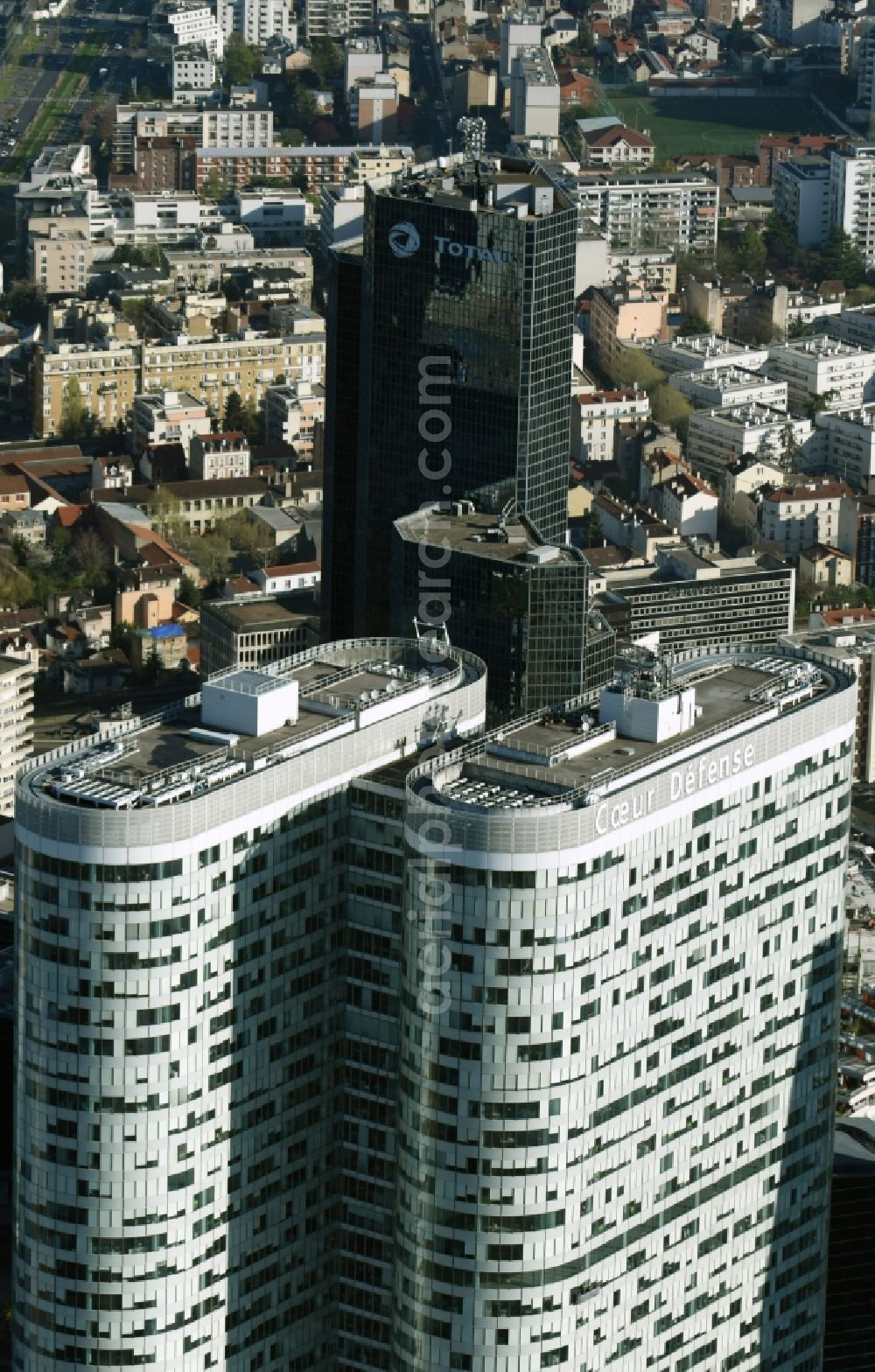 Paris from above - High-rise building Coeur Defense in the office and highrise quarter La Defense in Paris in Ile-de-France, France. The black skyscraper of the oil company Total Tour Total Coupole is located in the background