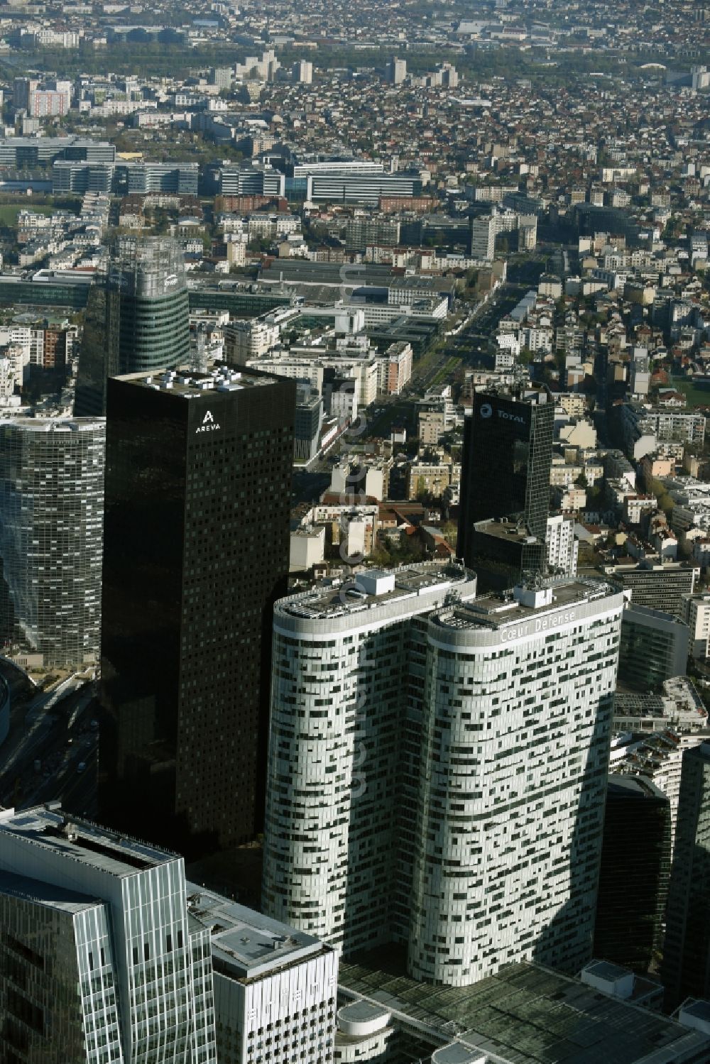 Aerial image Paris - High-rise building Coeur Defense in the office and highrise quarter La Defense in Paris in Ile-de-France, France. The black skyscraper of the oil company Total Tour Total Coupole is located in the background. Tour Areva with the French nuclear company is located next to it