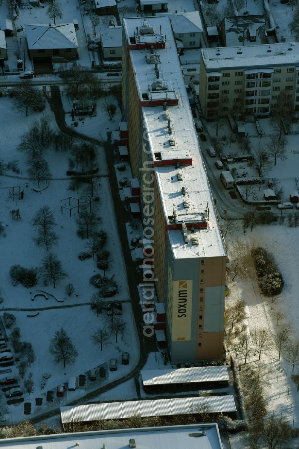 Berlin from the bird's eye view: Winterly snowy high-rise building of the company SAXUM BERLIN GMBH in the residential area besides the road Oberfeldstrasse in the district Marzahn-Hellersdorf in Berlin in Germany