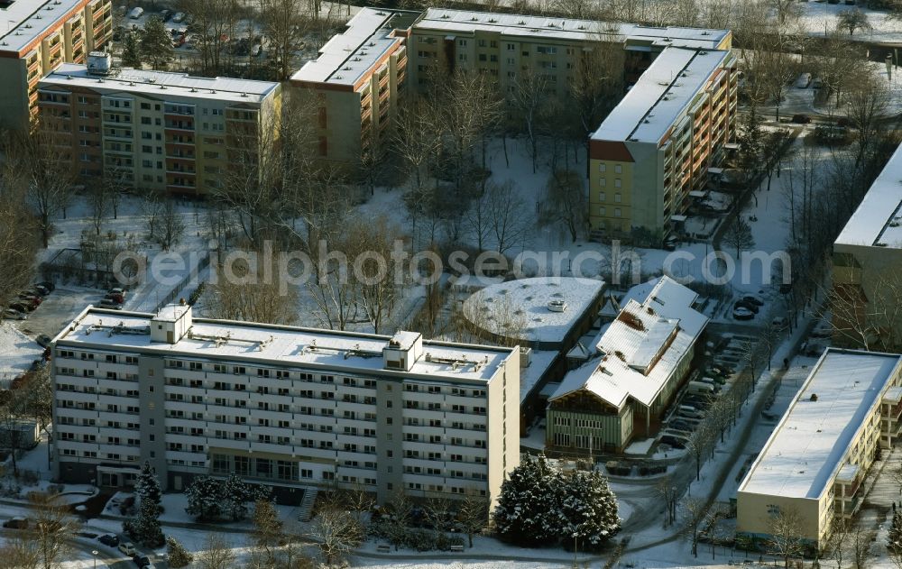 Aerial photograph Berlin - Winterly snowy view on high-rise building in the residential area and the building of the Berliner Werkstaetten fuer Menschen mit Behinderung aswell as the Theodorus Hospizes besides the road Blumberger Damm in Berlin in Germany