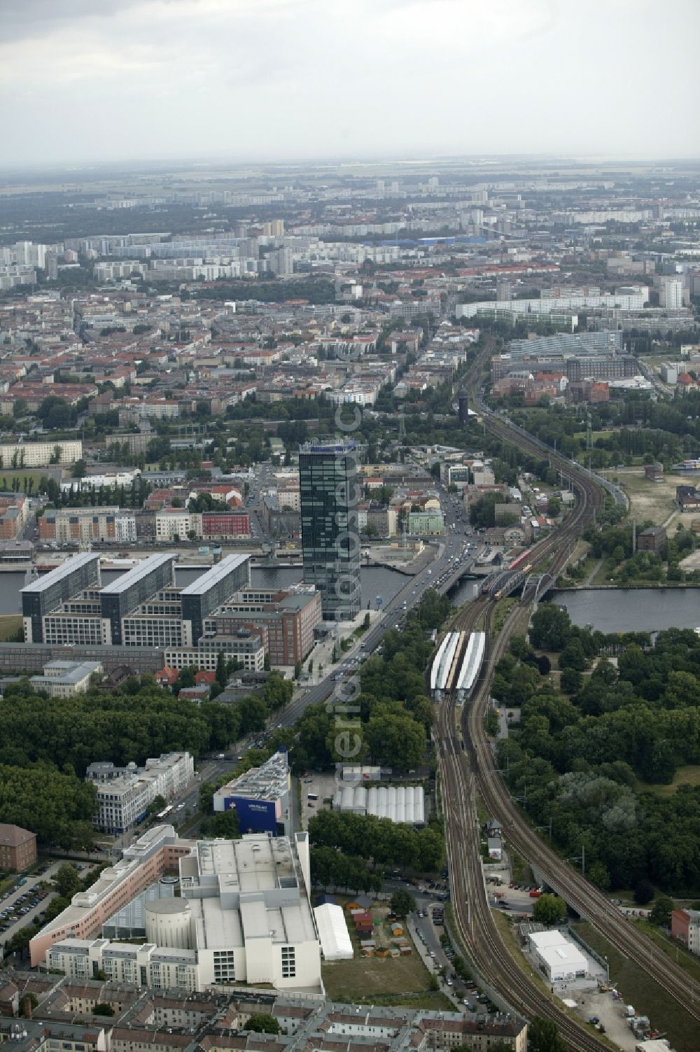 Aerial image Berlin - At the point where Elsen bridge crosses the River Spree in Berlin in the state of Berlin and the districts of Friedrichshain and Treptow is the high-rise Treptower. In the modern office complex at the Martin Hoffmann-road amongst the Allianz insurance company has its headquarters. Parallel to Elsen bridge run the tracks of the S-Bahn and mainline north. The next stop on the circle line is the east cross. On the record is still the old breakpoint to see with the distinctive water tower. In the foreground is the Treptow Park Center to see a shopping center