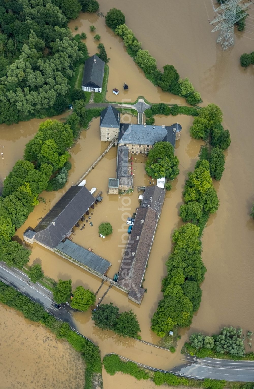 Hattingen from the bird's eye view: Flood situation and flooding, all-rousing and infrastructure-destroying masses of brown water at the fortress of the castle Haus Kemnade An der Kemnade in Hattingen at Ruhrgebiet in the state North Rhine-Westphalia, Germany