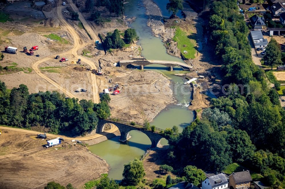 Dümpelfeld from the bird's eye view: Flood situation and flooding, all-rousing and infrastructure-destroying masses of brown water at the river Ahr with a destroyed bridge in Duempelfeld in the state Rhineland-Palatinate, Germany