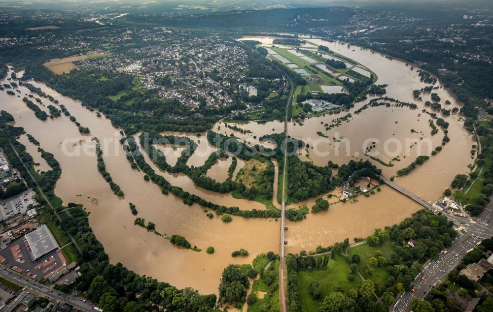 Essen from the bird's eye view: Flood situation and flooding, all-rousing and infrastructure-destroying masses of brown water on the course of the river Ruhr in the district Ueberruhr - Hinsel in Essen at Ruhrgebiet in the state North Rhine-Westphalia, Germany