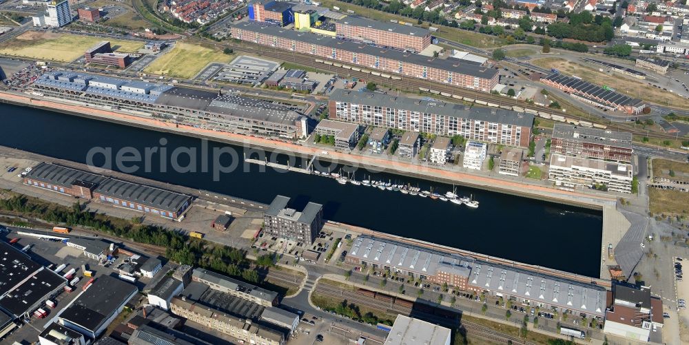 Aerial photograph Bremen - Holzhafen and Fabrikhafen harbours in the newly developed urban quarter Ueberseestadt on the riverbank of the Weser in Bremen in Germany. Boats and ships are docked on Ueberseepromenade in front of new residential buildings