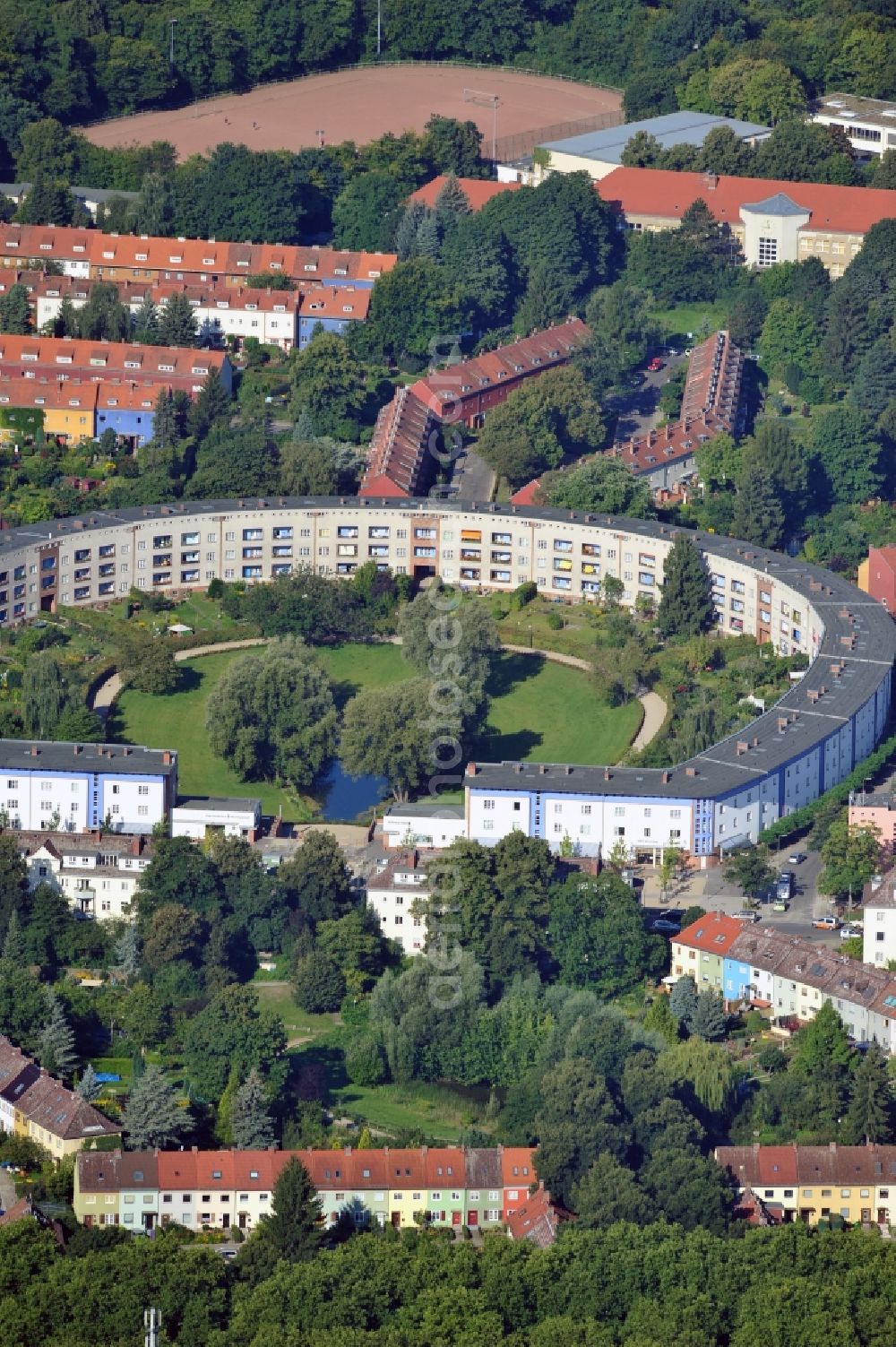 Berlin from above - View of Horseshoe settlement in Berlin-Britz. The Hufeisensiedlung was builded from 1925 to 1933 in Berlin-Britz, designed by Bruno Taut and Martin Wagner. It is one of the first projects of social housing and part of the large settlement Britz / Fritz Reuter city. Since 2008 it has been a UNESCO World Heritage Site. The horseshoe itself is still owned by the GEHAG, under the roof of the Deutsche Wohnen AG