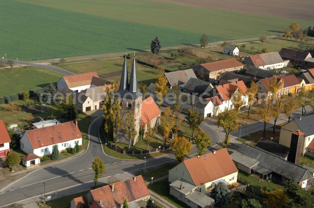 Ihlow from above - Blick auf Ihlow im Landkreis Teltow-Fläming in Brandenburg. Der Ort zeigt für diese Region typische Bauerhöfe und große Ackerflächen auf. Die Kirche in der Dorfmitte wurde im 13. Jahrhundert erbaut und hat einen zweispitzigen Kirchturm, der einzigartig im Fläming ist.