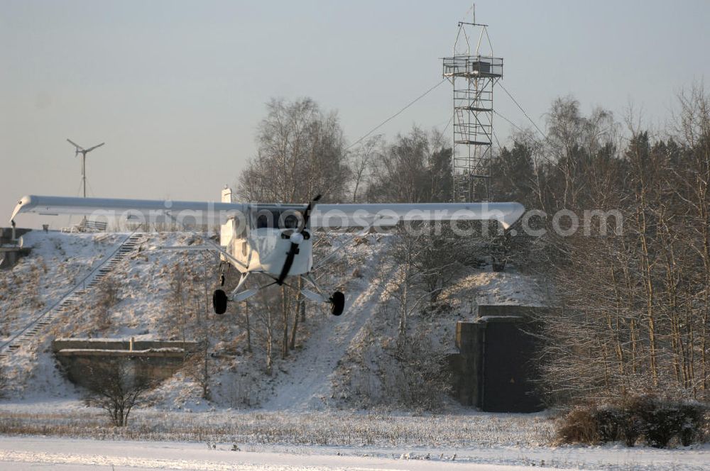 Aerial photograph WERNEUCHEN - Tiefer Überflug auf dem Flugplatz Werneuchen durch ein modernes Ultraleichtflugzeug. Ultraleichtflugzeug (UL) vom Typ Wild Thing WT 01, es ist eigentlich für australische Verhältnisse gebaut, ist aber in Deutschland in Hassfurt in einer Variante für den europäischen Markt produziert. Das Ultraleichtflugzeug zur Verfügung stellt das durch seine Robustheit, die gutmütigen Flugeigenschaften und Großräumigkeit im Innenraum ein beliebtes Ausbildungsflugzeug für deutsche Flugschulen dar.