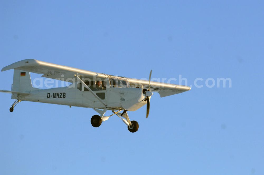 Aerial photograph WERNEUCHEN - Tiefer Überflug auf dem Flugplatz Werneuchen durch ein modernes Ultraleichtflugzeug. Ultraleichtflugzeug (UL) vom Typ Wild Thing WT 01, es ist eigentlich für australische Verhältnisse gebaut, ist aber in Deutschland in Hassfurt in einer Variante für den europäischen Markt produziert. Das Ultraleichtflugzeug zur Verfügung stellt das durch seine Robustheit, die gutmütigen Flugeigenschaften und Großräumigkeit im Innenraum ein beliebtes Ausbildungsflugzeug für deutsche Flugschulen dar.