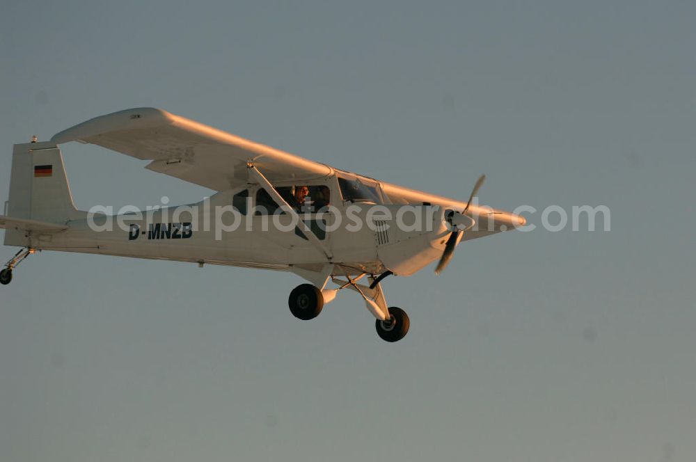 WERNEUCHEN from the bird's eye view: Tiefer Überflug auf dem Flugplatz Werneuchen durch ein modernes Ultraleichtflugzeug. Ultraleichtflugzeug (UL) vom Typ Wild Thing WT 01, es ist eigentlich für australische Verhältnisse gebaut, ist aber in Deutschland in Hassfurt in einer Variante für den europäischen Markt produziert. Das Ultraleichtflugzeug zur Verfügung stellt das durch seine Robustheit, die gutmütigen Flugeigenschaften und Großräumigkeit im Innenraum ein beliebtes Ausbildungsflugzeug für deutsche Flugschulen dar.