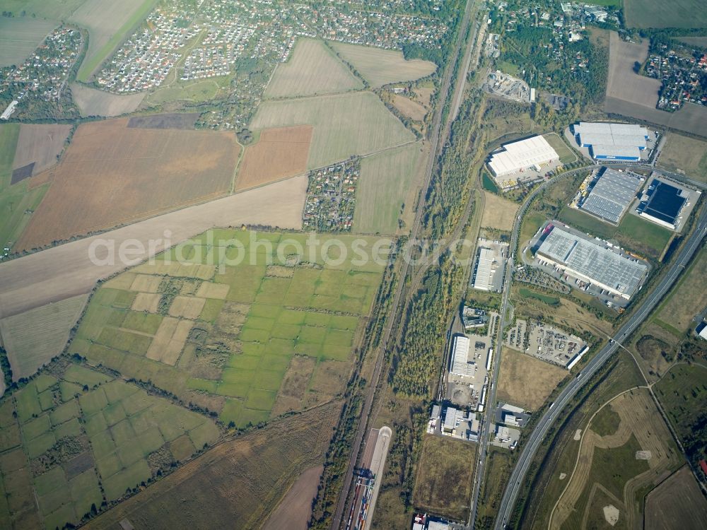 Großbeeren from the bird's eye view: Industrial estate and company settlement along the B101 road in Grossbeeren in the state of Brandenburg. The area with its different companies and business areas is surrounded by the residential areas of Grossbeeren and Teltow and by fields and meadows