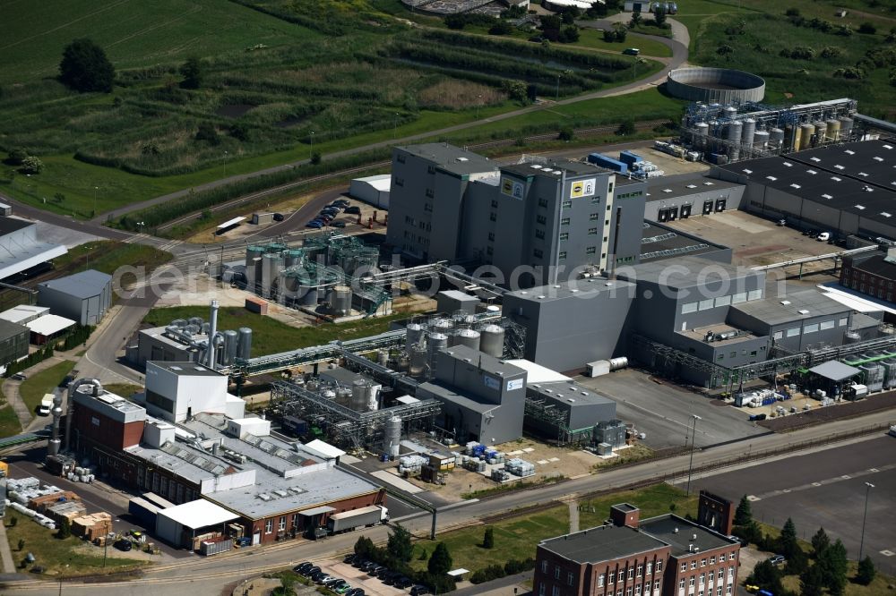 Genthin from the bird's eye view: Industrial and commercial area Industriepark Waschmittelwerk on the riverbanks of the Elbe-Havel-Canal in the North of Genthin in the state of Saxony-Anhalt. Several companies such as the washing detergent company Genthin GmbH or Solvay are located at the redeveloped historical industrial site