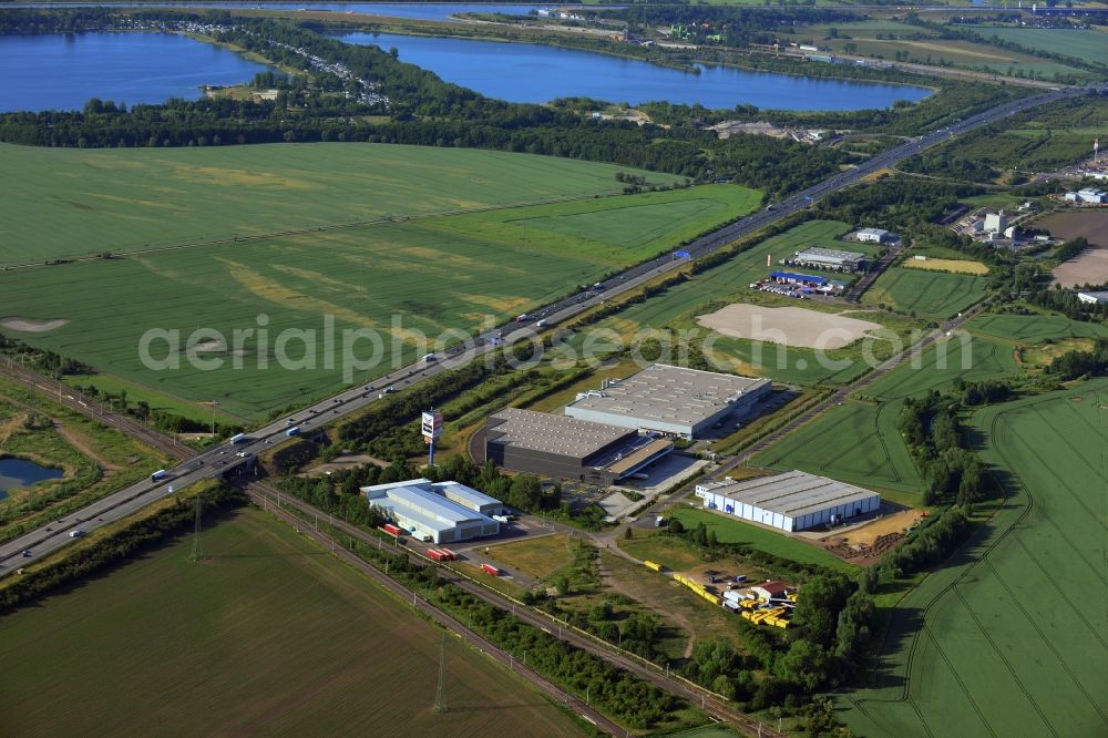 Aerial photograph Magdeburg - Industrial and commercial area along the A2 in the North of Magdeburg in the state of Saxony-Anhalt. The company buildings and halls along the federal motorway A2 are located on the Western edge of the commercial area North. They are surrounded by fields. The background shows the lake Barleber See II