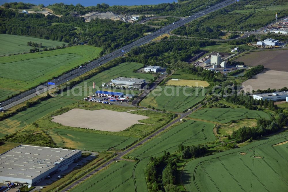 Magdeburg from above - Industrial and commercial area along the A2 in the North of Magdeburg in the state of Saxony-Anhalt. The company buildings and halls along the federal motorway A2 are located on the Western edge of the commercial area North. They are surrounded by fields. The background shows the lake Barleber See II