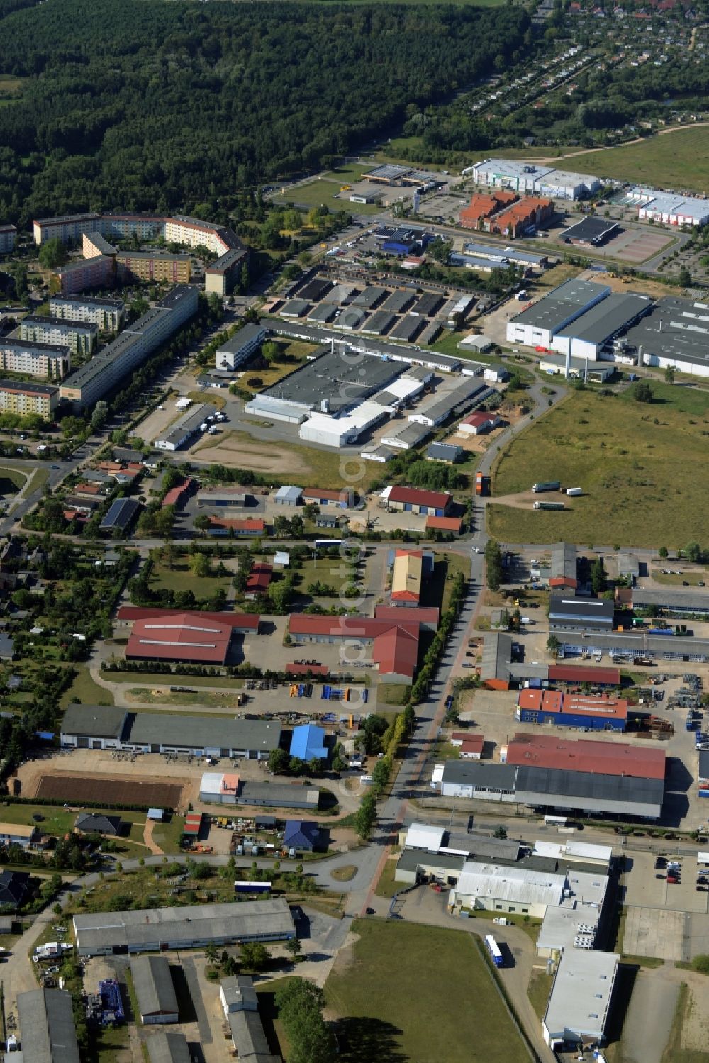 Waren (Müritz) from the bird's eye view: Industrial estate and company settlement in the West of Waren (Mueritz) in the state Mecklenburg - Western Pomerania. The area with its company settlements and compounds as well as facilities of the town works of Waren is located along Ernst-Alban-Strasse in the West of the town