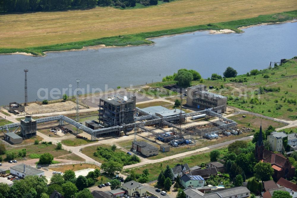 Magdeburg from the bird's eye view: Industrial area on the riverbank of the Elbe and former compound of Fahlberg-List in Magdeburg in the state Saxony-Anhalt.The historic buildings of the former sugar factory with its elongated hall and three silos on the riverbank are listed as protected buildings. The area belongs to the Wusterhuesen and Salbke parts in the South of Magdeburg