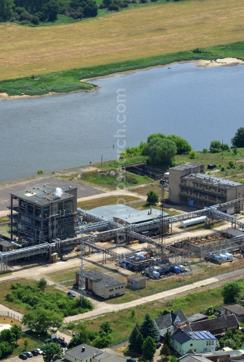 Aerial image Magdeburg - Industrial area on the riverbank of the Elbe and former compound of Fahlberg-List in Magdeburg in the state Saxony-Anhalt.The historic buildings of the former sugar factory with its elongated hall and three silos on the riverbank are listed as protected buildings. The area belongs to the Wusterhuesen and Salbke parts in the South of Magdeburg