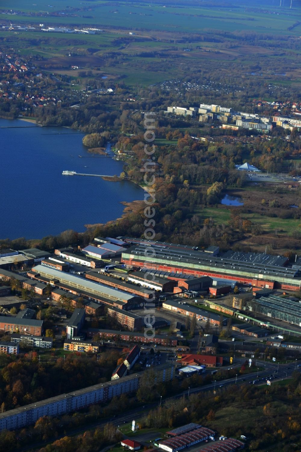 Neubrandenburg from the bird's eye view: View of industrial area by the Tollensesee as well as surrounding houses and cultural park with green areas in Neubrandenburg in the state Mecklenburg-West Pomerania. The following companies have their production facilities as well as warehousing and logistics halls: Werkzeugbau GmbH, UPS Depot der United Parcel Service Deutschland Inc. & Co. OHG, WEKA Holzbau GmbH, ATN Auto Service Neubrandenburg, NTN GmbH IVECO Vertragswerkstatt, LAMAHA GmbH, Metallbau MBM Zan der, N-A-F-T GmbH, PV Automotive GmbH, Handwerkskammer East Mecklenburg - Western Pomerania ( education center Neubrandenburg ). The area is located along the road Neustrelitzer Strasse