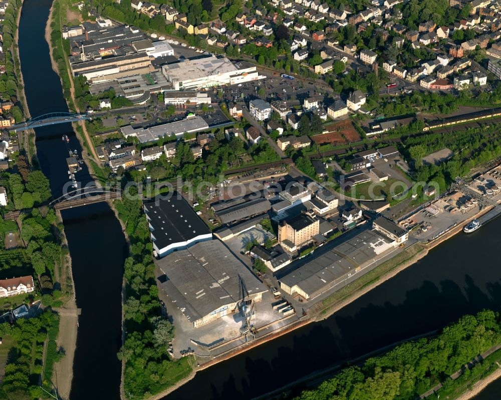 Lahnstein from the bird's eye view: Industrial area on the riverbanks of the Rhine and the Lahn in Lahnstein in the state Rhineland-Palatinate. The town is located in the county district of Rhine-Lahn, at the mouth of the river Lahn into the river Rhine. The spa resort includes thermal spas and health centres and sits in the UNESCO world heritage site of Upper Middle Rhine Valley. The industrial area is located in the North of the town centre of Lahnstein and includes a wharf and pool