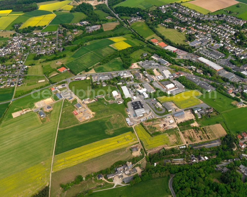 Nastätten from the bird's eye view: Industrial area in the West of the town of Nastaetten in the state of Rhineland-Palatinate. The official tourist resort is located in the county district of Rhine-Lahn, in the Western Hintertaunus mountain region and is the centre of the so-called Blue Country. The town consists of residential areas, includes an industrial area and is surrounded by rapeseed fields and meadows