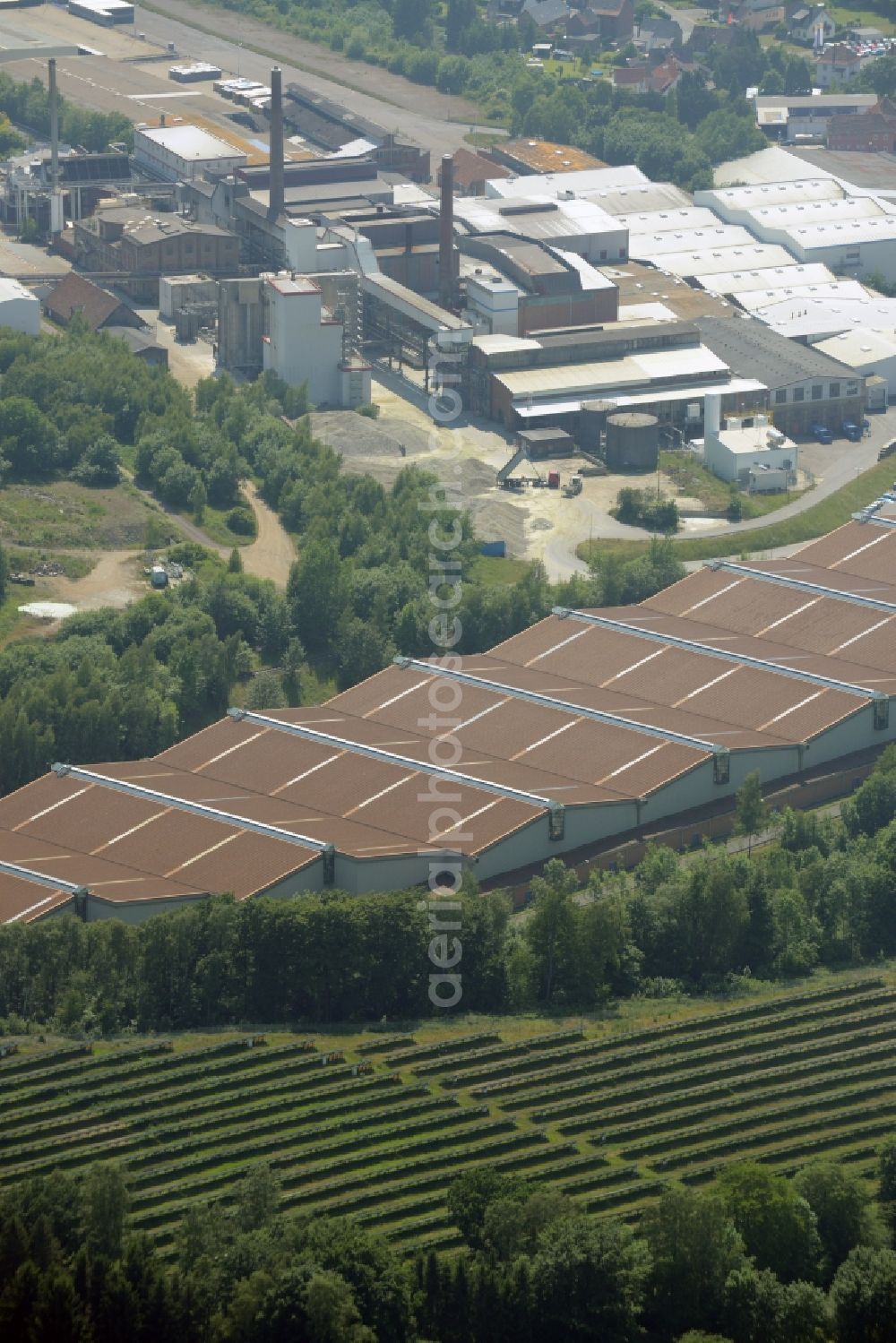 Obernkirchen from above - Industrial compound and production site of Ardagh Glass in Obernkirchen in the state of Lower Saxony. The large site with different buildings, halls and the large distinct hall with red-brown roof is the site of two Ardagh Glass companies that produce for the international glass industry: Heye International and Schaumburger Formenbau GmbH