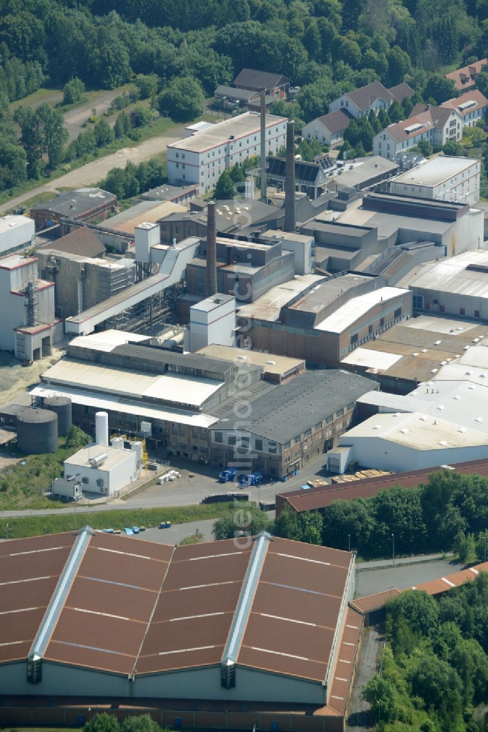 Aerial photograph Obernkirchen - Industrial compound and production site of Ardagh Glass in Obernkirchen in the state of Lower Saxony. The large site with different buildings, halls and the large distinct hall with red-brown roof is the site of two Ardagh Glass companies that produce for the international glass industry: Heye International and Schaumburger Formenbau GmbH