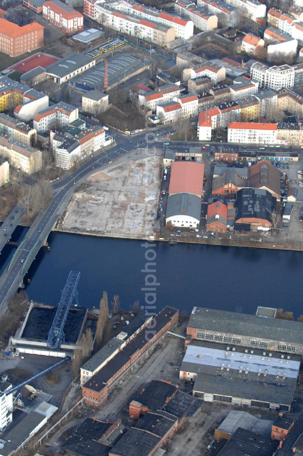 Aerial image Berlin - Blick auf das Industriegebiet an der Stubenrauchbrücke im Berliner Stadtbezirk Treptow-Köpenick. Am Ufer der Spree befindet sich auf der östlichen Seite der Brücke das im Umbruch befindliche Industriegebiet Oberschöneweide mit denkmalgeschützten Fasbrikgebäuden, auf der westlichen Seite liegt das Gewerbegebiet Niederschöneweide.