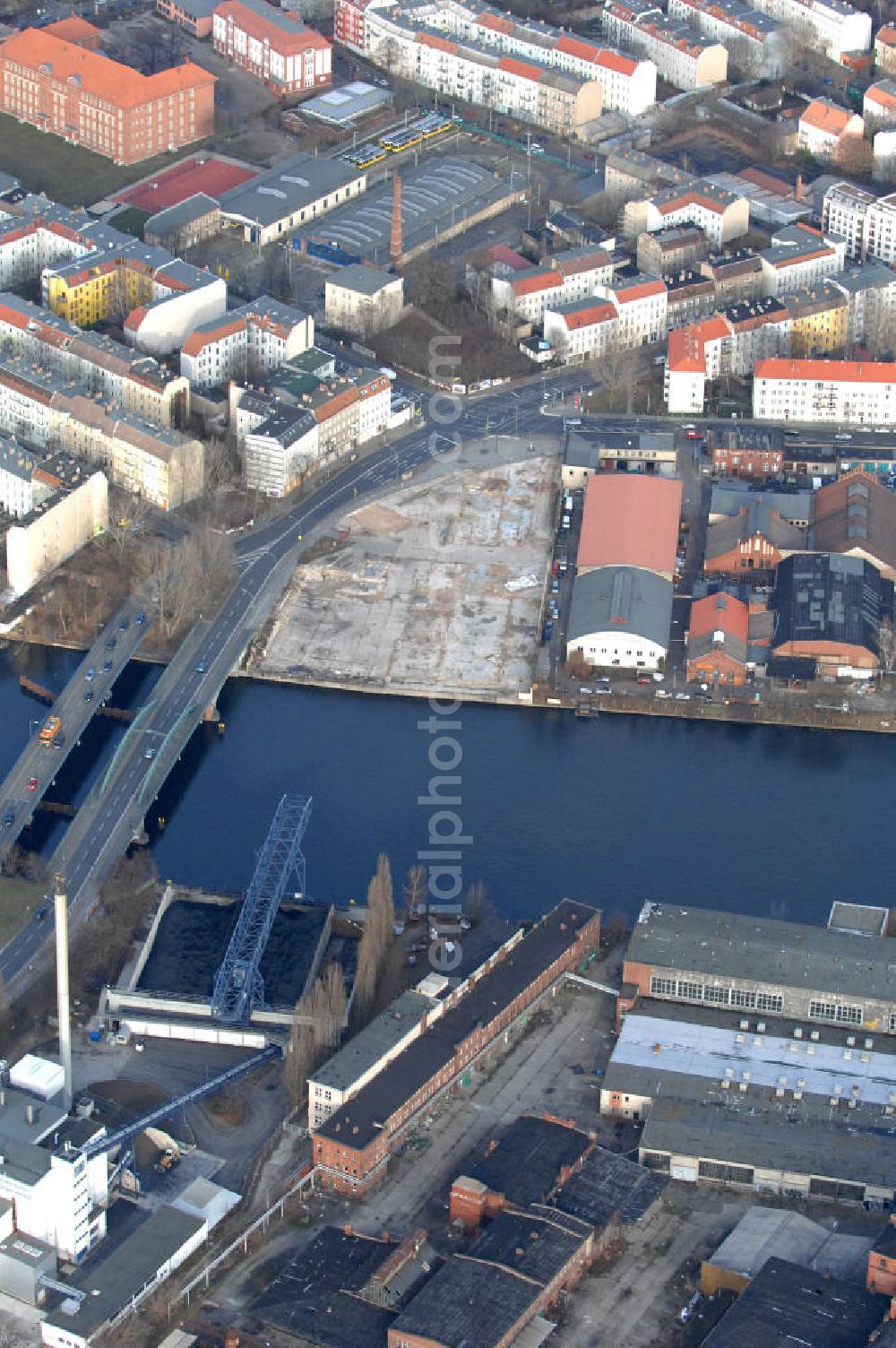 Aerial photograph Berlin - Blick auf das Industriegebiet an der Stubenrauchbrücke im Berliner Stadtbezirk Treptow-Köpenick. Am Ufer der Spree befindet sich auf der östlichen Seite der Brücke das im Umbruch befindliche Industriegebiet Oberschöneweide mit denkmalgeschützten Fasbrikgebäuden, auf der westlichen Seite liegt das Gewerbegebiet Niederschöneweide.