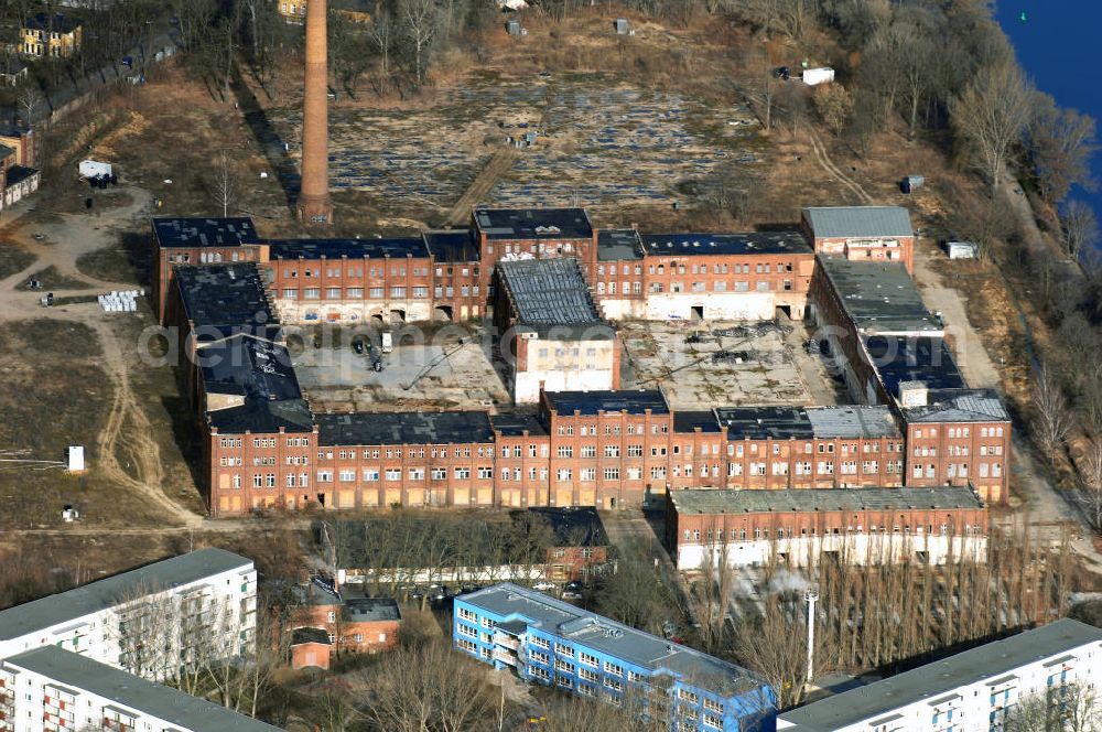 Berlin from above - Blick auf eine der größten Industrieruinen Berlins, der ehemaligen REWATEX-Wäscherei in Spindlersfeld.Die Firma W. Spindler (kurz für Wilhelm Spindler) war ein Wäscherei- und Färberei-Unternehmen, das 1832 von Wilhelm Spindler in Berlin gegründet und später durch seinen Sohn Carl Spindler geleitet wurde. Es hatte seit 1873 seinen Hauptsitz in Berlin-Spindlersfeld und unterhielt dort die Anstalt zur chemischen Reinigung, Wäscherei und Färberei. Es war zu seiner Zeit der größte deutsche Wäschereibetrieb und der Vorreiter der Chemischen Reinigung in Deutschland. Anfang der 1920er wurde es von der Schering AG übernommen und bildete zu DDR-Zeiten das Stammwerk des VEB Rewatex, später Rewatex AG.Nach der Wende wurde das Unternehmen in REWATEX AG umfirmiert und 1992 von der Kölner Larosé Hygiene-Service-GmbH übernommen. Diese setzte den Betrieb auf dem Gelände Spindlersfeld aber nur bis Mitte der 90er fort, alle Aktivitäten wurden in den Betriebsteil Grünauer Straße verlagert. Im Jahr 2000 war die Imhoff-Industrieholding Eigentümer des Geländes. [6] Die Anlagen in Spindlersfeld sind heute nur noch eine Industrieruine. Einige Gebäude wurden abgerissen, die übrigen unter Denkmalschutz gestellt. Es stehen noch in der Ottomar-Geschke-Straße die Gebäude am Haupteingang und der Kindergarten, das große Hauptgebäude (Ringbau), in der Ernst-Grube-Straße ein Verwaltungsgebäude von 1905 und ein hoher Schornstein. Im Jahr 2003 begann ein Programm zur Altlastensanierung des Geländes, das heute (Juli 2006) noch andauert. Es ist geplant, im Ringbau „wohnverträgliches Gewerbe unterzubringen“ und das übrige Gelände mit Wohnhäusern und Stadtvillen zu bebauen. AENGEVELT Immobilien KG.