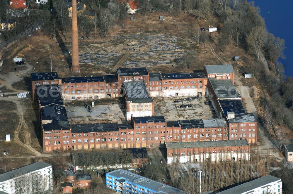 Berlin from the bird's eye view: Blick auf eine der größten Industrieruinen Berlins, der ehemaligen REWATEX-Wäscherei in Spindlersfeld.Die Firma W. Spindler (kurz für Wilhelm Spindler) war ein Wäscherei- und Färberei-Unternehmen, das 1832 von Wilhelm Spindler in Berlin gegründet und später durch seinen Sohn Carl Spindler geleitet wurde. Es hatte seit 1873 seinen Hauptsitz in Berlin-Spindlersfeld und unterhielt dort die Anstalt zur chemischen Reinigung, Wäscherei und Färberei. Es war zu seiner Zeit der größte deutsche Wäschereibetrieb und der Vorreiter der Chemischen Reinigung in Deutschland. Anfang der 1920er wurde es von der Schering AG übernommen und bildete zu DDR-Zeiten das Stammwerk des VEB Rewatex, später Rewatex AG.Nach der Wende wurde das Unternehmen in REWATEX AG umfirmiert und 1992 von der Kölner Larosé Hygiene-Service-GmbH übernommen. Diese setzte den Betrieb auf dem Gelände Spindlersfeld aber nur bis Mitte der 90er fort, alle Aktivitäten wurden in den Betriebsteil Grünauer Straße verlagert. Im Jahr 2000 war die Imhoff-Industrieholding Eigentümer des Geländes. [6] Die Anlagen in Spindlersfeld sind heute nur noch eine Industrieruine. Einige Gebäude wurden abgerissen, die übrigen unter Denkmalschutz gestellt. Es stehen noch in der Ottomar-Geschke-Straße die Gebäude am Haupteingang und der Kindergarten, das große Hauptgebäude (Ringbau), in der Ernst-Grube-Straße ein Verwaltungsgebäude von 1905 und ein hoher Schornstein. Im Jahr 2003 begann ein Programm zur Altlastensanierung des Geländes, das heute (Juli 2006) noch andauert. Es ist geplant, im Ringbau „wohnverträgliches Gewerbe unterzubringen“ und das übrige Gelände mit Wohnhäusern und Stadtvillen zu bebauen. AENGEVELT Immobilien KG.