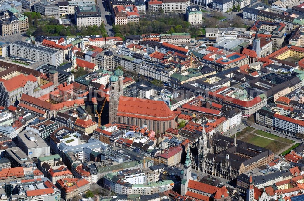 Aerial photograph München - Munich city center, overlooking the Frauenkirche, New City Hall and the parish church of St. Peter. The Frauenkirche (center) is the cathedral church of the Archbishop of Munich and Freising and is considered a symbol of the Bavarian capital. The three-aisled late Gothic brick building with a surrounding ring of chapels is 109 m long, 40 meters wide and 37 meters high. The foundation stone for today's woman in the church was built in 1468 by Duke Sigismund