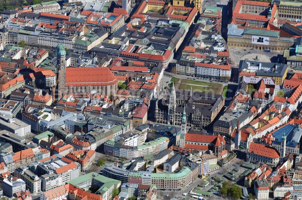 München from above - Munich city center, overlooking the Frauenkirche, New City Hall and the parish church of St. Peter. The Frauenkirche (center) is the cathedral church of the Archbishop of Munich and Freising and is considered a symbol of the Bavarian capital. The three-aisled late Gothic brick building with a surrounding ring of chapels is 109 m long, 40 meters wide and 37 meters high. The foundation stone for today's woman in the church was built in 1468 by Duke Sigismund