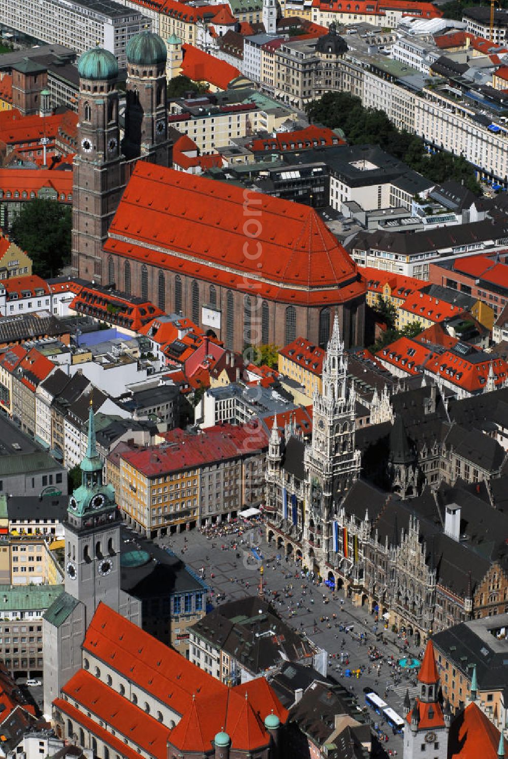 Aerial image München - Innenstadt von München mit Blick auf die Frauenkirche, das Neue Rathaus und die Pfarrkirche St. Peter. Die Frauenkirche (obere Bildmitte) ist die Kathedralkirche des Erzbischofs von München und Freising und gilt als Wahrzeichen der bayerischen Landeshauptstadt. Der dreischiffige spätgotische Backsteinbau mit umlaufendem Kapellenkranz ist 109 m lang, 40 m breit und 37 m hoch. Die Grundsteinlegung für die heutige Frauenkirche erfolgte im Jahr 1468 durch Herzog Sigismund. Da man aus Kostengründen einen gemauerten Backsteinbau errichten wollte, statt auf teure Steinmetzarbeiten zurück zu greifen, wurde die Leitung der Bauarbeiten Jörg von Halspach, einem Maurermeister, übertragen. Im Jahr 1494 wurde die Frauenkirche geweiht. Im Zweiten Weltkrieg schwer beschädigt, wurde die Kirche in der Nachkriegszeit wieder aufgebaut, dabei erhielt sie ihr heutiges eher nüchternes, aber dennoch gewaltiges und markantes Äußeres. Von der ursprünglichen Ausstattung sind noch einige mittelalterliche Skulpturen und die mittelalterlichen Glasgemälde der Chorfenster erhalten geblieben. Mit ihrer herrlichen zentralen Lage inmitten einer großzügigen Fußgängerzone, die zwischen Karlsplatz und Marienplatz eingerichtet wurde, ist die Frauenkirche eine der meistbesuchtesten Sehenswürdigkeiten Münchens. Kontakt: Dom Zu Unserer Lieben Frau, Frauenplatz 12, 80331 München, Tel.: 089/290082-0, E-Mail: dompfarramt@muenchner-dom.de,