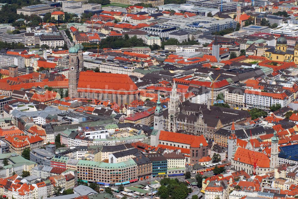 München from the bird's eye view: Innenstadt von München mit Blick auf die Frauenkirche, das Neue Rathaus und die Pfarrkirche St. Peter. Die Frauenkirche (Bildmitte) ist die Kathedralkirche des Erzbischofs von München und Freising und gilt als Wahrzeichen der bayerischen Landeshauptstadt. Der dreischiffige spätgotische Backsteinbau mit umlaufendem Kapellenkranz ist 109 m lang, 40 m breit und 37 m hoch. Die Grundsteinlegung für die heutige Frauenkirche erfolgte im Jahr 1468 durch Herzog Sigismund. Da man aus Kostengründen einen gemauerten Backsteinbau errichten wollte, statt auf teure Steinmetzarbeiten zurück zu greifen, wurde die Leitung der Bauarbeiten Jörg von Halspach, einem Maurermeister, übertragen. Im Jahr 1494 wurde die Frauenkirche geweiht. Im Zweiten Weltkrieg schwer beschädigt, wurde die Kirche in der Nachkriegszeit wieder aufgebaut, dabei erhielt sie ihr heutiges eher nüchternes, aber dennoch gewaltiges und markantes Äußeres. Von der ursprünglichen Ausstattung sind noch einige mittelalterliche Skulpturen und die mittelalterlichen Glasgemälde der Chorfenster erhalten geblieben. Mit ihrer herrlichen zentralen Lage inmitten einer großzügigen Fußgängerzone, die zwischen Karlsplatz und Marienplatz eingerichtet wurde, ist die Frauenkirche eine der meistbesuchtesten Sehenswürdigkeiten Münchens. Kontakt: Dom Zu Unserer Lieben Frau, Frauenplatz 12, 80331 München, Tel.: 089/290082-0, E-Mail: dompfarramt@muenchner-dom.de,