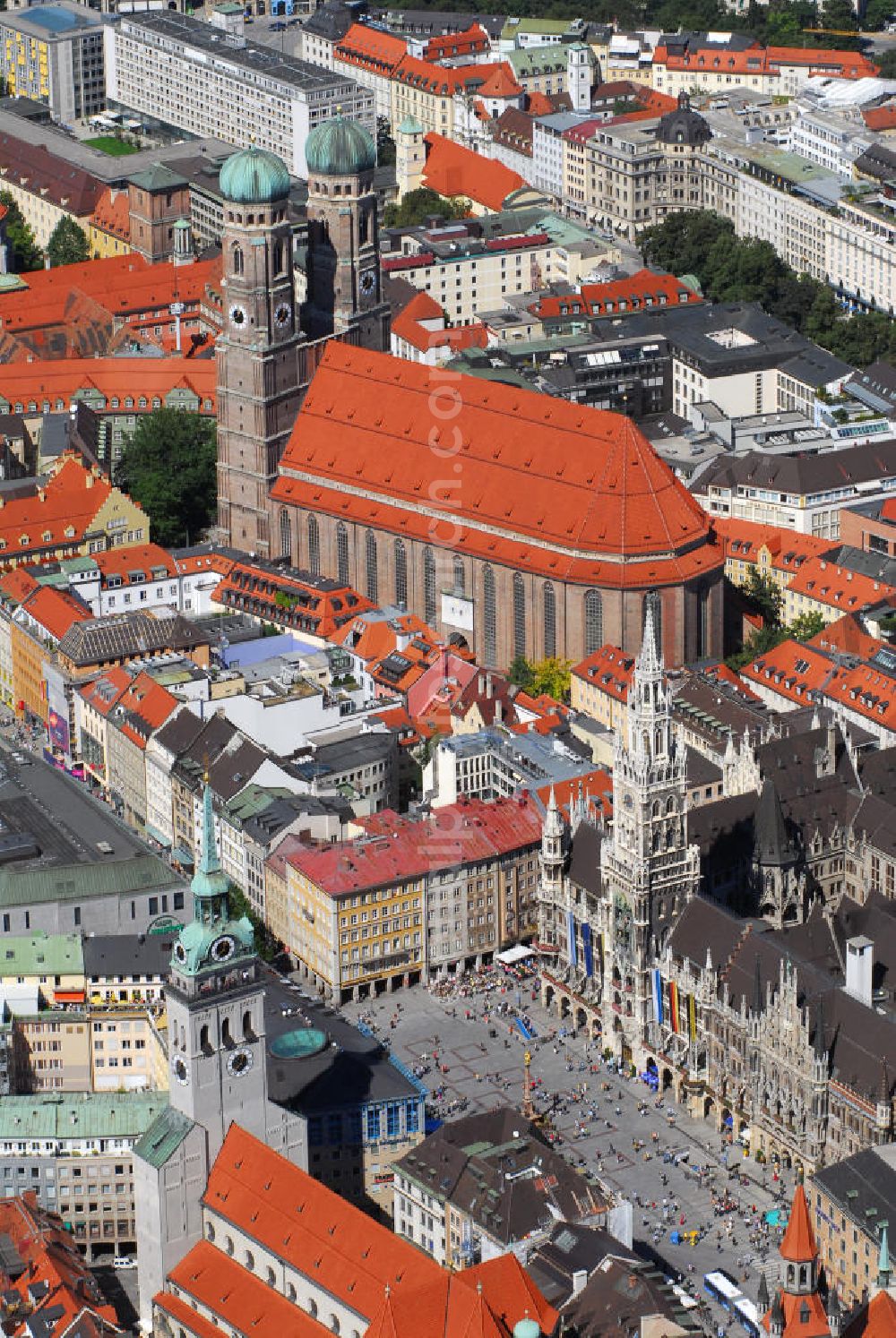 Aerial image München - Innenstadt von München mit Blick auf die Frauenkirche, das Neue Rathaus und die Pfarrkirche St. Peter. Die Frauenkirche (obere Bildmitte) ist die Kathedralkirche des Erzbischofs von München und Freising und gilt als Wahrzeichen der bayerischen Landeshauptstadt. Der dreischiffige spätgotische Backsteinbau mit umlaufendem Kapellenkranz ist 109 m lang, 40 m breit und 37 m hoch. Die Grundsteinlegung für die heutige Frauenkirche erfolgte im Jahr 1468 durch Herzog Sigismund. Da man aus Kostengründen einen gemauerten Backsteinbau errichten wollte, statt auf teure Steinmetzarbeiten zurück zu greifen, wurde die Leitung der Bauarbeiten Jörg von Halspach, einem Maurermeister, übertragen. Im Jahr 1494 wurde die Frauenkirche geweiht. Im Zweiten Weltkrieg schwer beschädigt, wurde die Kirche in der Nachkriegszeit wieder aufgebaut, dabei erhielt sie ihr heutiges eher nüchternes, aber dennoch gewaltiges und markantes Äußeres. Von der ursprünglichen Ausstattung sind noch einige mittelalterliche Skulpturen und die mittelalterlichen Glasgemälde der Chorfenster erhalten geblieben. Mit ihrer herrlichen zentralen Lage inmitten einer großzügigen Fußgängerzone, die zwischen Karlsplatz und Marienplatz eingerichtet wurde, ist die Frauenkirche eine der meistbesuchtesten Sehenswürdigkeiten Münchens. Kontakt: Dom Zu Unserer Lieben Frau, Frauenplatz 12, 80331 München, Tel.: 089/290082-0, E-Mail: dompfarramt@muenchner-dom.de,